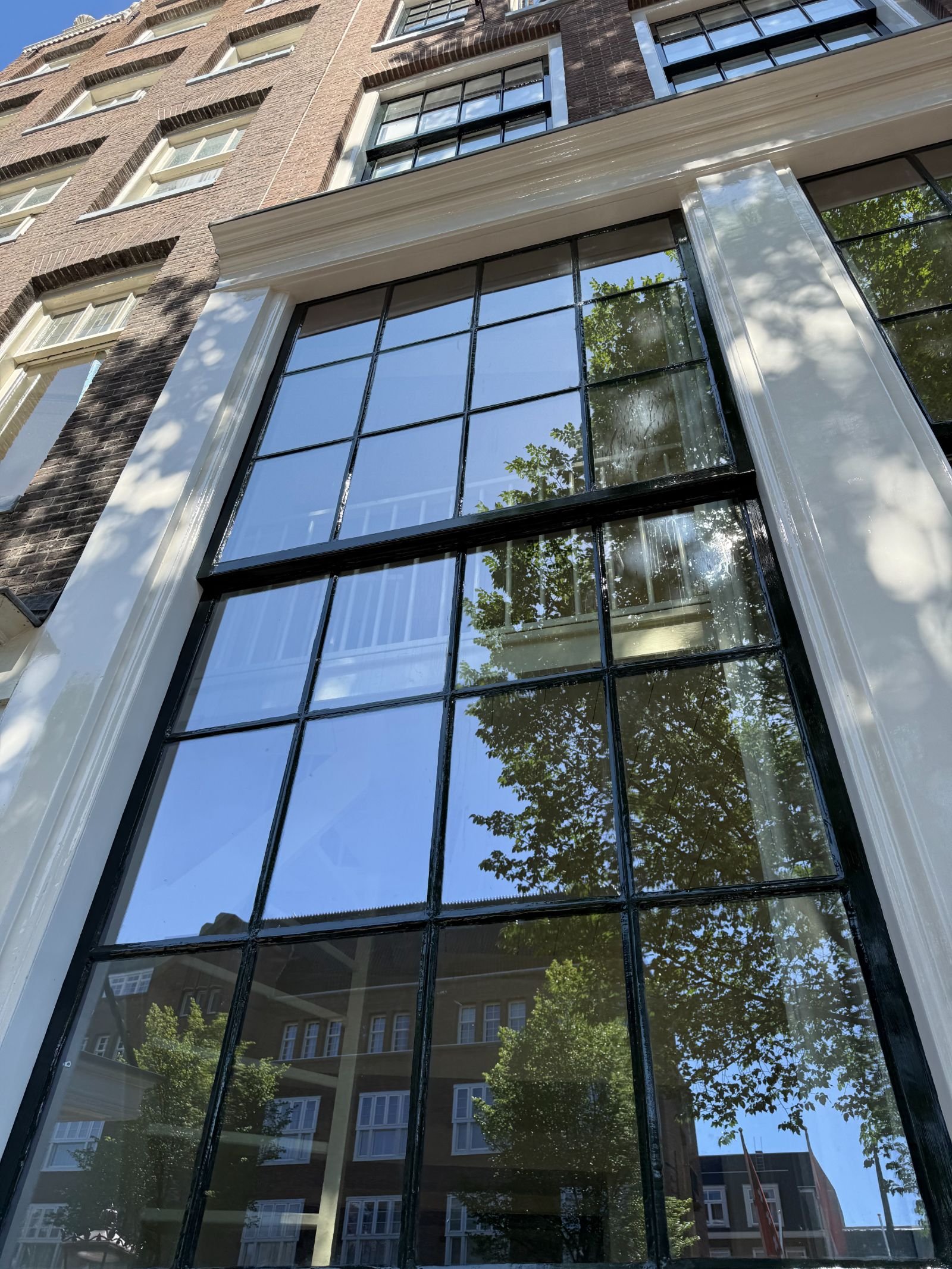 Detail van geplaatst vacuümglas met strakke kitranden en zwart geschilderde roedes